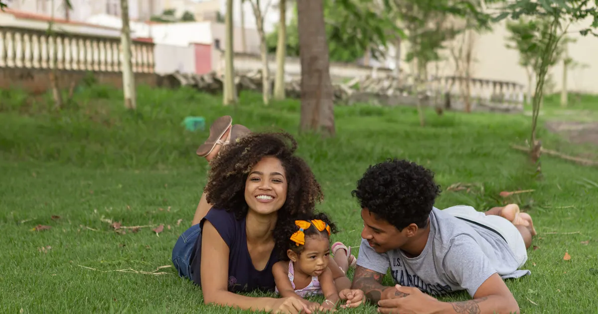 A family resting together on grass in a park